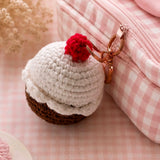 Crochet cupcake keychain clipped to a pink gingham pouch