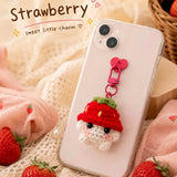 Strawberry crochet phone charm on a pink phone
