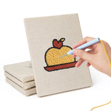 A hand crafting with a mini punch needle kit, creating a dessert motif on fabric.