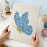 Punch needle kit featuring a blue butterfly design on textured fabric, perfect for crafting and relaxation.