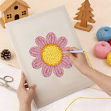 A person using a punch needle kit to create a pink daisy flower design on a canvas.